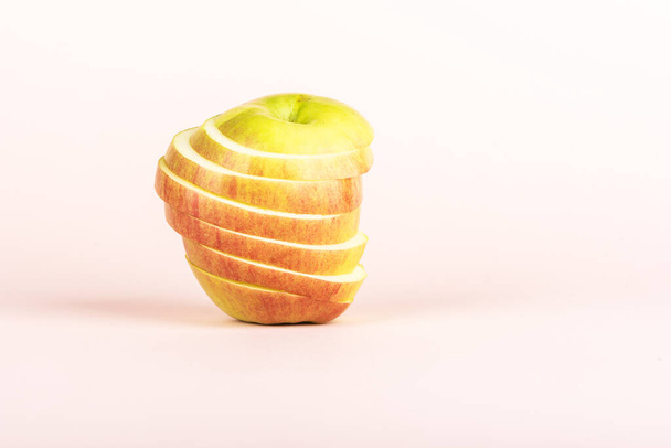 Sliced apple on a pale pink background with space for text. Close up. - Foto, Imagen