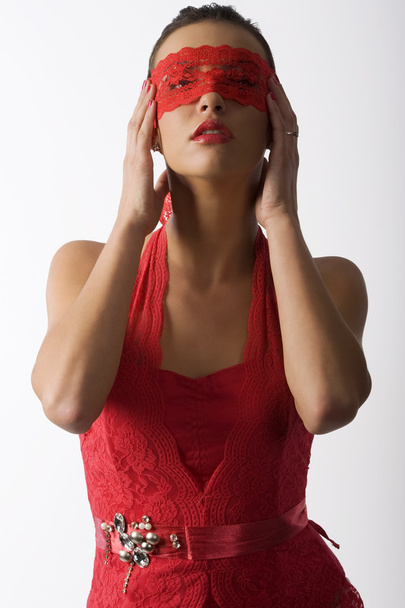 милая и сексуальная брюнетка в красной кружевной рубашке и красной кружевной маске, смотрящая вверх
 - Фото, изображение