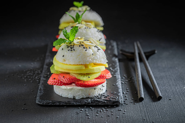 Unique sush burger with fresh tropical fruits on stone plate. Japanese cuisine. - Фото, зображення