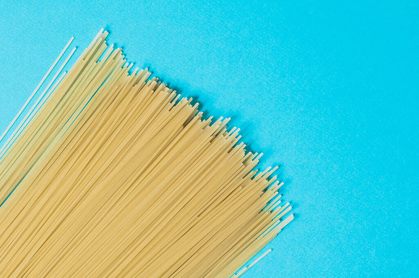 Spaghetti on a blue background. Top view. - Фото, зображення
