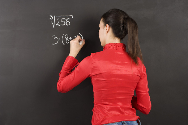 pretty young college student writing on the chalkboard/blackboard during a math class - Fotó, kép