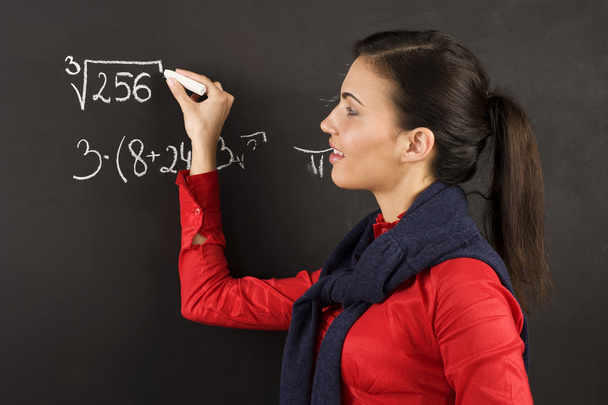 pretty young college student writing on the chalkboard/blackboard during a math class - Foto, Bild
