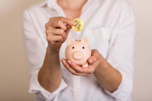 Sparschwein mit Bitcoin-Münze auf hellem Hintergrund, Platz für Text. Finanzen, Geld sparen - Foto, Bild