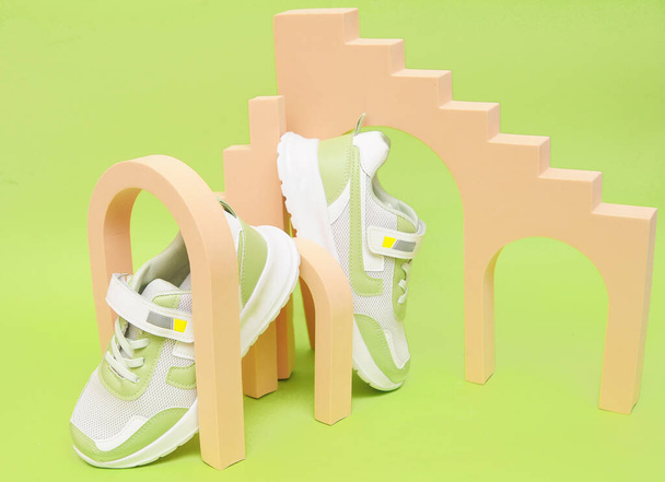  Μοντέρνα πράσινα παπούτσια σε πολύχρωμο φόντο. Αθλητικά μοντέρνα παπούτσια. - Φωτογραφία, εικόνα