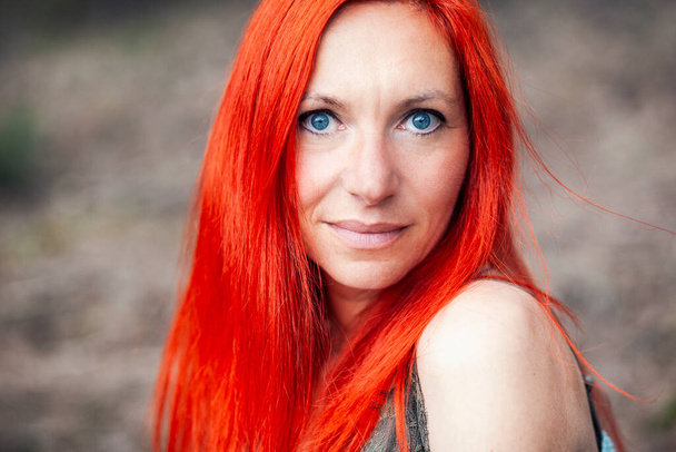 Doğanın arka planında poz veren kızıl saçlı kadın. - Fotoğraf, Görsel
