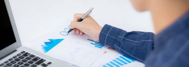 Молодий азіатський бізнесмен вказує на графік і графік даних документа з ручкою, маркетингом та інвестиціями, звіт про статистичний прибуток для фінансів, економіки та зростання фінансів, управління та планування
. - Фото, зображення