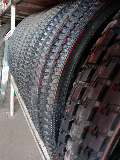 черный цвет велосипедных шин на складе в магазине на продажу - Фото, изображение