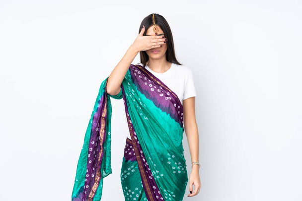 Молодая индийская женщина изолирована на белом фоне, закрывая глаза руками. Не хочу ничего видеть. - Фото, изображение