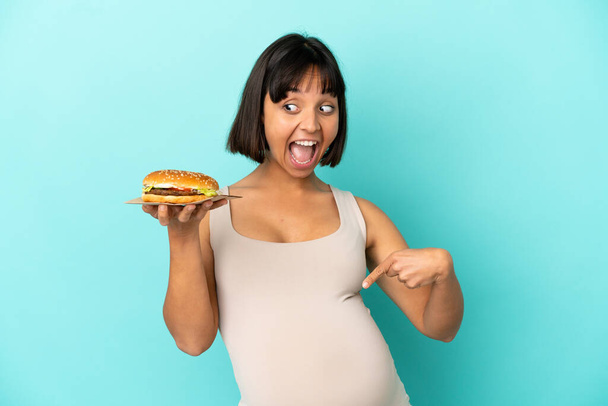 Молода вагітна жінка тримає сплеск над ізольованим тлом
 - Фото, зображення