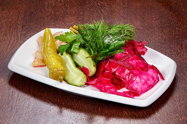 Mix van gepekelde groenten - kool, komkommer en peper geserveerd dille - Foto, afbeelding