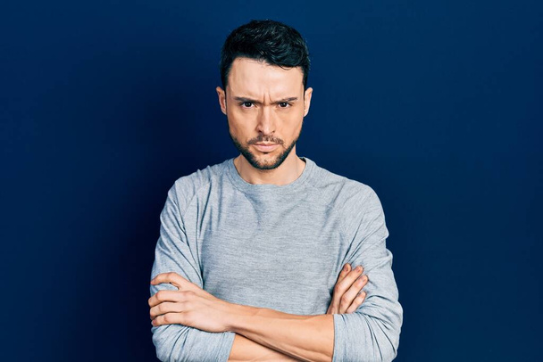 Young hispanic man wearing casual clothes skeptic and nervous, disapproving expression on face with crossed arms. negative person.  - Photo, Image