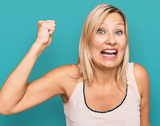 Middle age caucasian woman wearing casual clothes angry and mad raising fist frustrated and furious while shouting with anger. rage and aggressive concept.  - Photo, image
