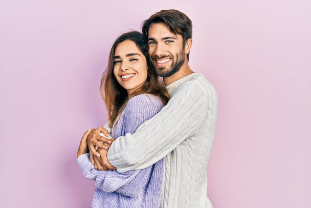 Young hispanic couple wearing casual clothes looking to side, relax profile pose with natural face and confident smile.  - Фото, зображення