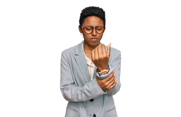 Молода афроамериканська жінка, одягнена в діловий одяг, страждає від болю рук і пальців, запалення артриту.  - Фото, зображення