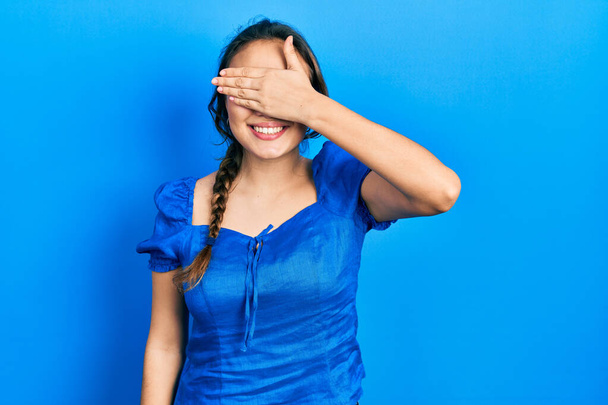 Nuori latino tyttö yllään rento vaatteita hymyilee ja nauraa käsin kasvot peittävät silmät yllätys. sokea käsite.  - Valokuva, kuva