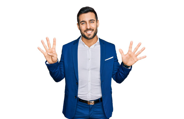 Nuori latinomies yllään liike takki näy ja osoittaa sormilla numero yhdeksän hymyillen itsevarma ja onnellinen.  - Valokuva, kuva