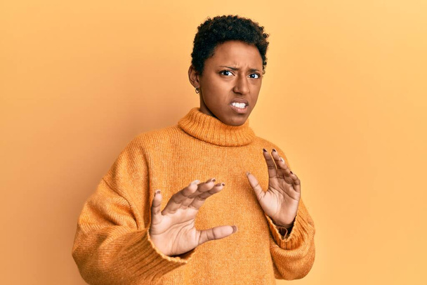 Junge afrikanisch-amerikanische Mädchen in lässiger Kleidung angewidert Ausdruck, unzufrieden und ängstlich tun Ekel Gesicht, weil Abneigung Reaktion. mit erhobenen Händen  - Foto, Bild