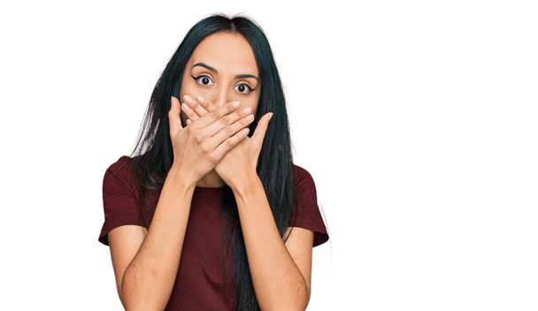 Young hispanic girl wearing casual t shirt shocked covering mouth with hands for mistake. secret concept.  - Photo, Image