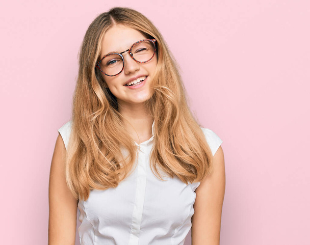 Beautiful young caucasian girl wearing casual clothes and glasses winking looking at the camera with sexy expression, cheerful and happy face.  - Foto, Imagen