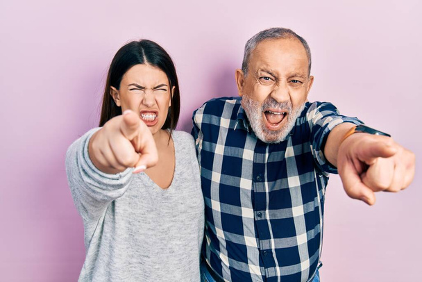 Hispanic father and daughter wearing casual clothes pointing displeased and frustrated to the camera, angry and furious with you  - Photo, Image