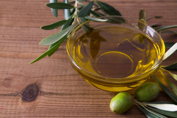 glass vessel with extra virgin olive oil and olives with branch - Photo, Image