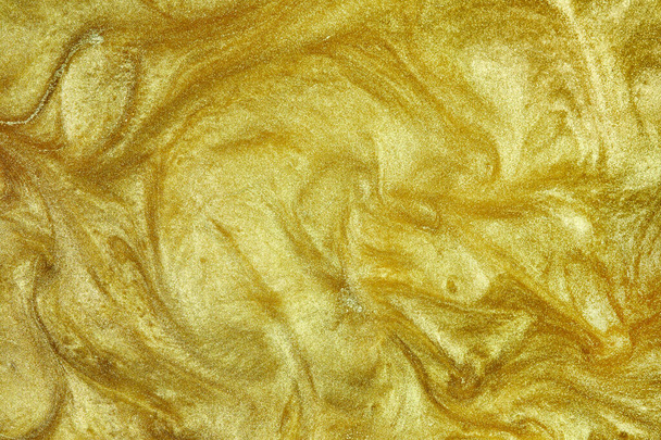 黄金の液体。流れる金の波状の表面。概要きらびやかな背景. - 写真・画像