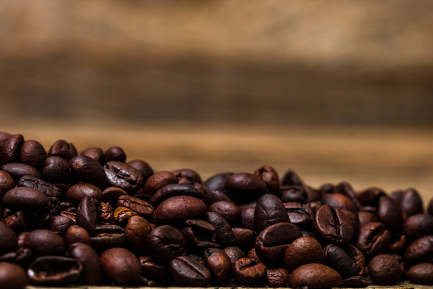 Roasted coffee beans isolated on wooden table. - Photo, Image