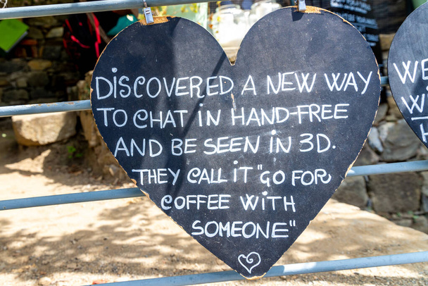 A heart made from a chalkboard with a saying that there is a new way of chatting, without a cell phone, in person over coffee - Photo, Image