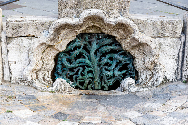 Der künstlerisch nostalgische und historische Abfluss der Piazza del Campo in Siena, der dafür sorgt, dass das Wasser auf dem großen Platz abfließen kann. Der Abfluss ist mit einem schmiedeeisernen Gitter verstopft. - Foto, Bild