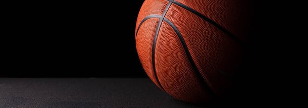 Gros plan d'une balle de basket-ball en caoutchouc avec espace vide. Fond sombre. - Photo, image