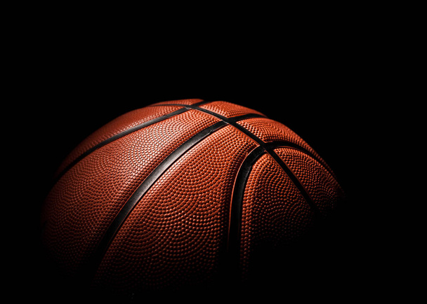 暗い背景にオレンジ色のクローズアップの美しいバスケットボールボール. - 写真・画像