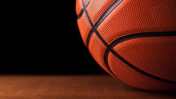 Basketballball auf Holzboden schwarzer Hintergrund. - Foto, Bild