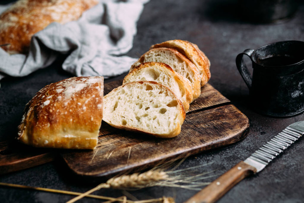 Домашний хлеб Чиабатта. Нарезанные ломтики хлеба на деревянной доске. Хлеб  - Фото, изображение