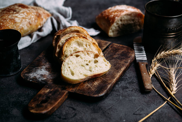 Саморобний хліб Чіабата. Нарізані шматочки хліба на дерев'яній дошці. Хліб
  - Фото, зображення