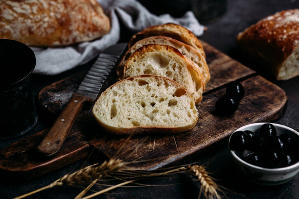 Pão de Ciabatta caseiro. fatias de pão fatiadas em uma tábua de madeira. Pão  - Foto, Imagem