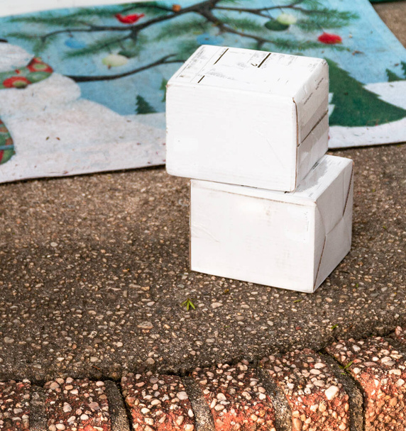 Two small white packages delivered to a front stoop left out exposed to the elements and thieves. - Photo, Image