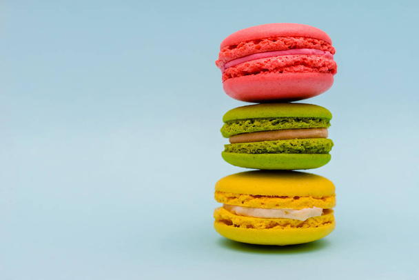 three multicolored macaron cakes on a blue background - Photo, Image