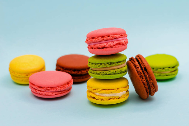 several multicolored macaron cakes on a blue background - Photo, Image