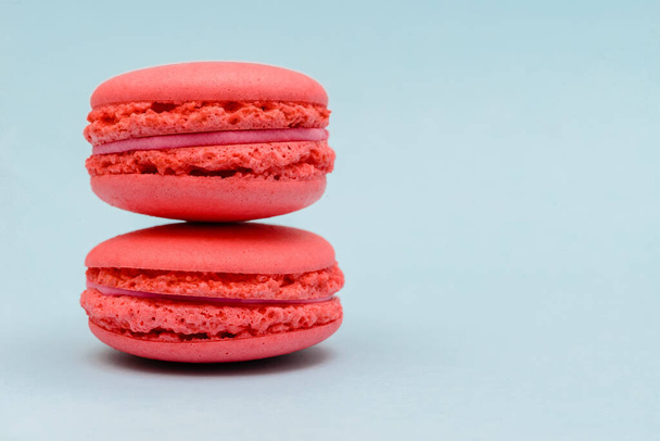 two pink macaron cakes on a blue background - Foto, imagen
