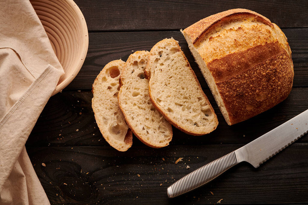 Freshly baked homemade tartine bread on dark wooden table - Photo, Image