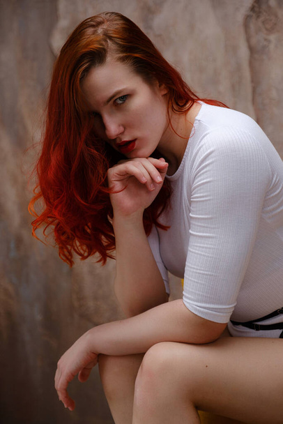 σέξι γυναίκα με μακριά κόκκινα μαλλιά ποζάρουν με λευκά εσώρουχα σε λευκό φόντο στούντιο. Ευεξία, αποτρίχωση, φροντίδα σώματος. Γιόγκα και γυμναστήριο, πραγματική ομορφιά και σώμα θετικά - Φωτογραφία, εικόνα