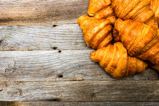 Deliziosi croissant freschi isolati su tavola di legno. Concetto colazione francese. - Foto, immagini