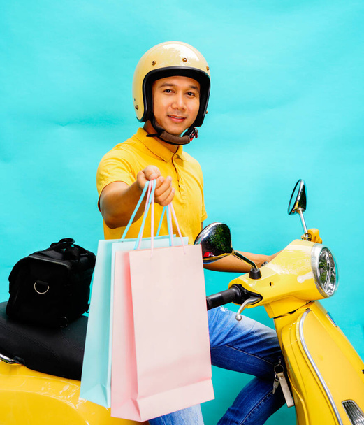 Livreur Riding Moto à la livraison de nourriture ou de colis service express. Homme heureux livrant aux clients - Photo, image