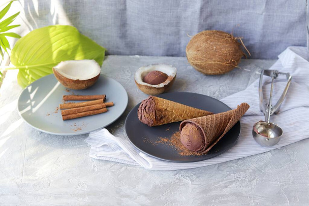 Σπιτικό παγωτό σοκολάτα σε κώνους βάφλας, καρύδες σε ελαφρύ τραπέζι, σπιτικά προϊόντα μαγειρικής, υγιεινά τρόφιμα - Φωτογραφία, εικόνα