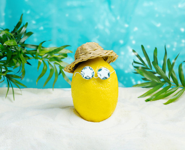 Lemon in hat and sunglasses  relaxes on beach. Summer tropical minimal humor poster. - Fotoğraf, Görsel