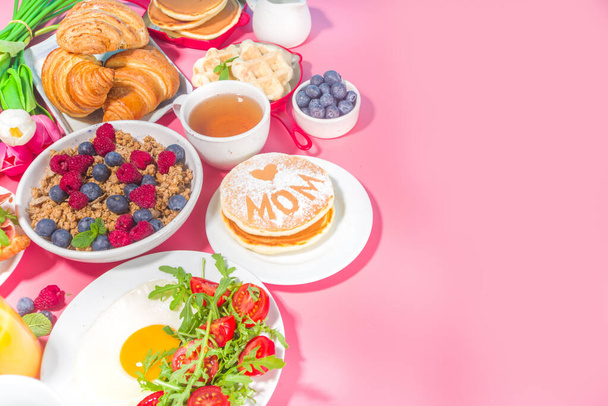 Mothers day Brunch restaurant invitation concept. Various Moms Womans Day Menu background, with traditional breakfast and lunch food and drink set, with flowers on sunny pink background - Photo, Image