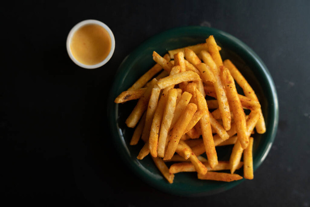 French fries in a bowl with sauce dip on a wooden background. - Photo, Image