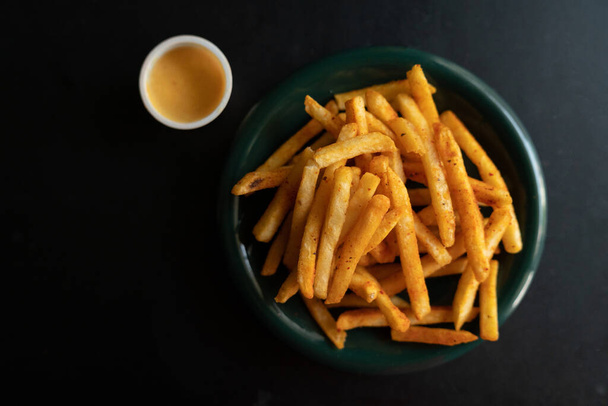 French fries in a bowl with sauce dip on a wooden background. - Photo, Image