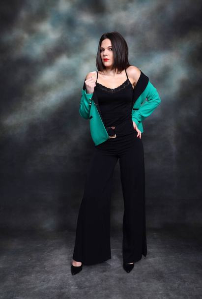 Attractive girl with black hair is posing in studio. Style, trends, fashion concept. - Photo, Image