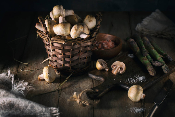 Basket with champignons and asparagus on a rustic table - Foto, Imagem